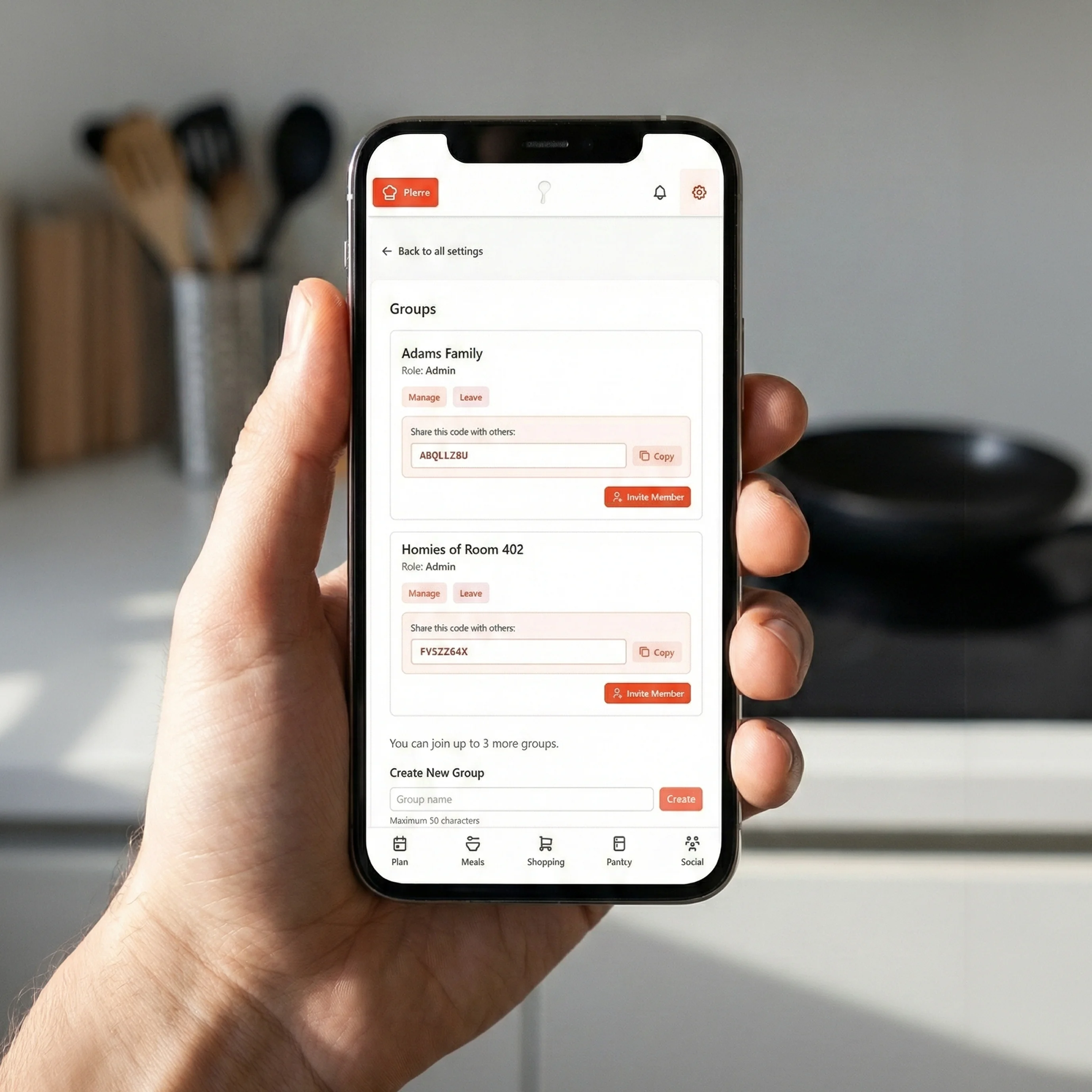 Hand holding smartphone displaying GoodSpoon group settings interface with shared calendars and member management