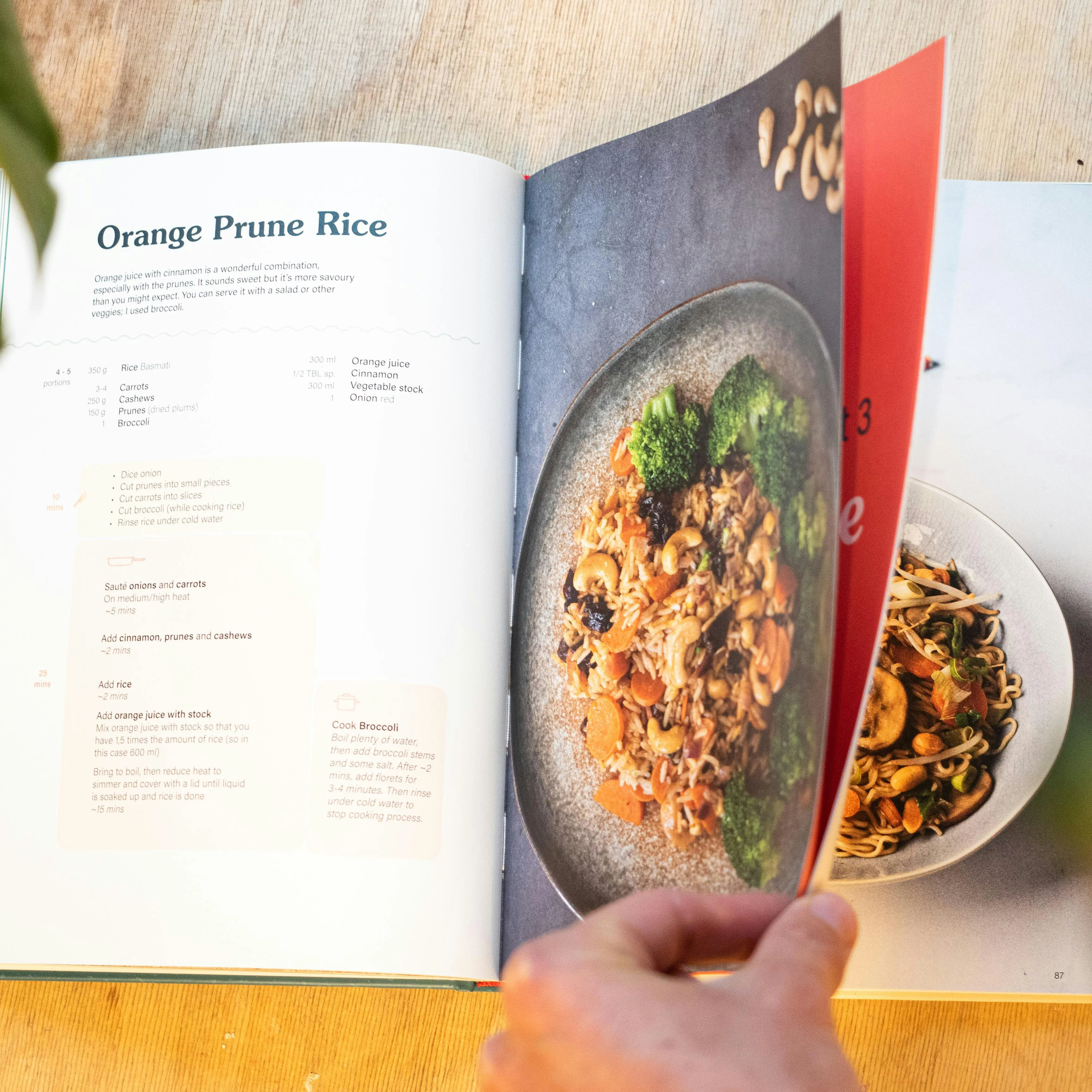 Person flipping through pages of a recipe book, selecting favorite meals to add to their GoodSpoon meal library