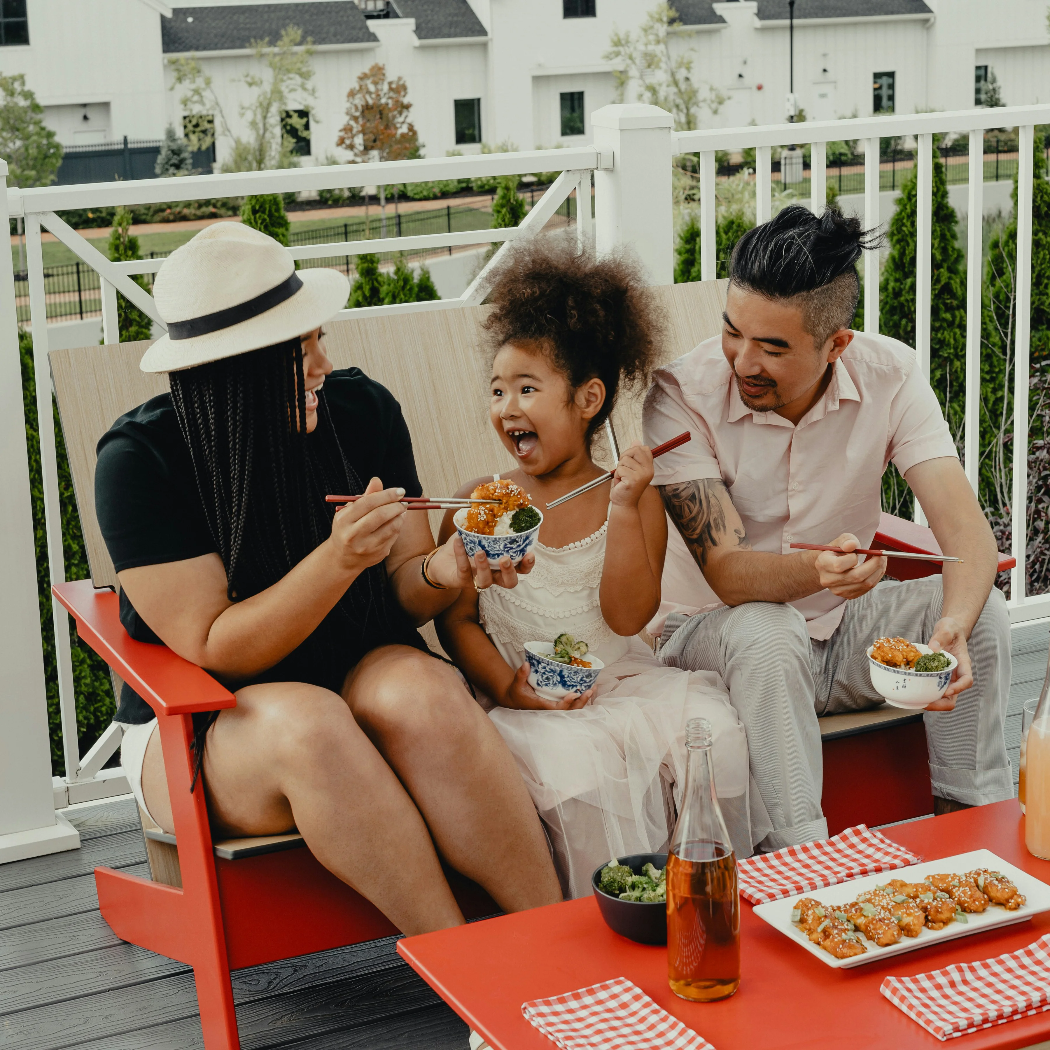 Family of three enjoying dinner together on their outdoor deck, demonstrating collaborative meal planning